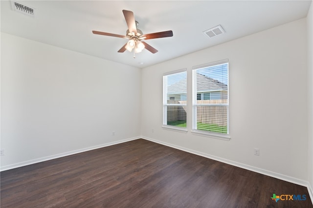 spare room featuring dark wood-type flooring and ceiling fan