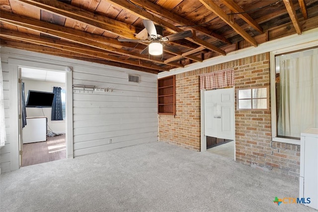 215 Taylor Rd, Elgin, TX 78621 - empty room with carpet floors, brick wall, beamed ceiling, wood ceiling, and a ceiling fan