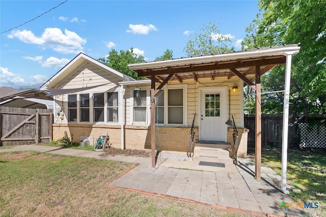 215 Taylor Rd, Elgin, TX 78621 - back of property with a yard, brick siding, fence, and a gate