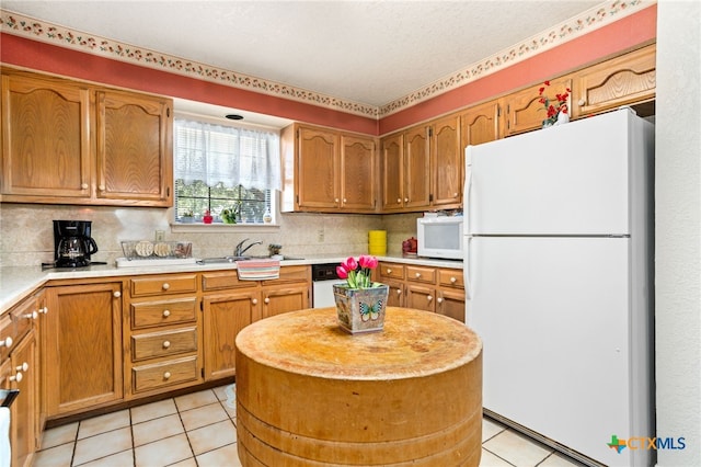 kitchen with decorative backsplash, sink, light tile patterned flooring, and white appliances