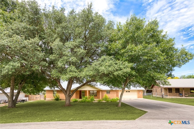 ranch-style home with a garage and a front lawn