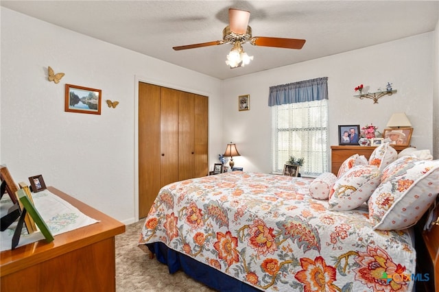 bedroom featuring ceiling fan, a closet, and carpet