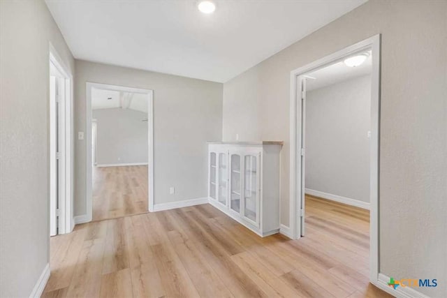 spare room featuring light wood-style flooring and baseboards