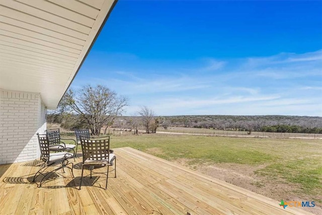 deck featuring a rural view and a lawn