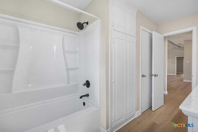 full bathroom with shower / bath combination and wood finished floors