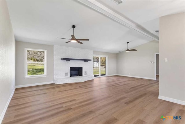 unfurnished living room with wood finished floors, a ceiling fan, and a healthy amount of sunlight