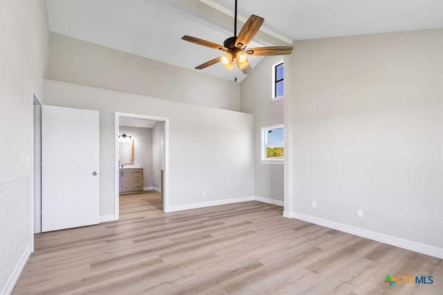 unfurnished bedroom with beamed ceiling, high vaulted ceiling, baseboards, and wood finished floors