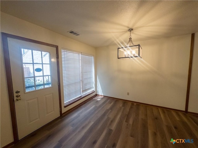101 Maplewood Dr Unit 28, Victoria, TX 77901 - unfurnished dining area featuring a chandelier, wood finished floors, baseboards, and a textured ceiling