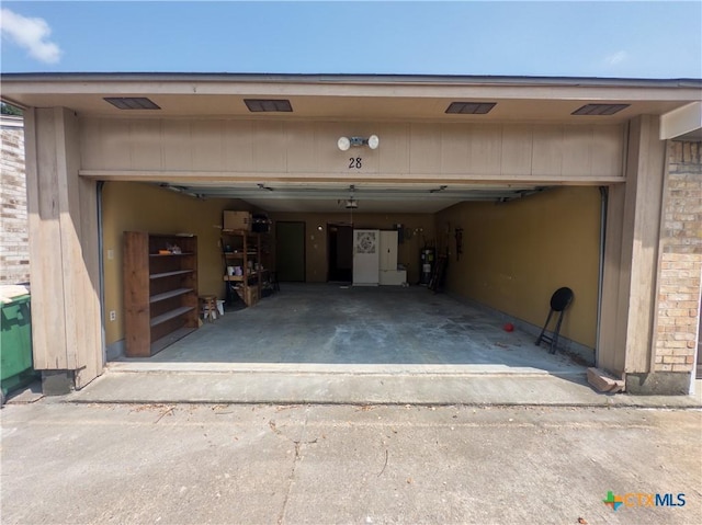 101 Maplewood Dr Unit 28, Victoria, TX 77901 - garage featuring driveway and electric water heater