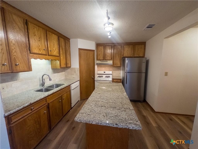 101 Maplewood Dr Unit 28, Victoria, TX 77901 - kitchen featuring white appliances, a sink, brown cabinetry, backsplash, and a textured ceiling