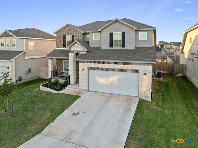 view of front of home with central air condition unit, a garage, and a front lawn