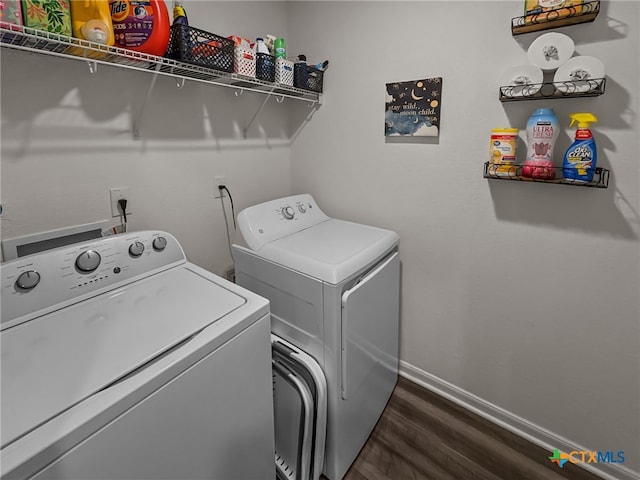 clothes washing area with dark wood-type flooring and washer and dryer