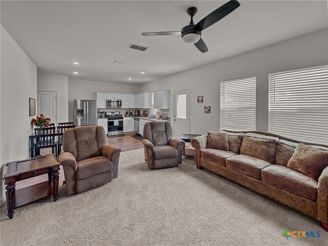 living room with light wood-type flooring and ceiling fan