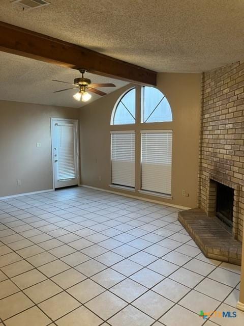 unfurnished living room with a brick fireplace, a textured ceiling, ceiling fan, light tile patterned floors, and vaulted ceiling with beams