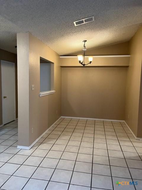 unfurnished room featuring a textured ceiling, light tile patterned floors, vaulted ceiling, and a notable chandelier