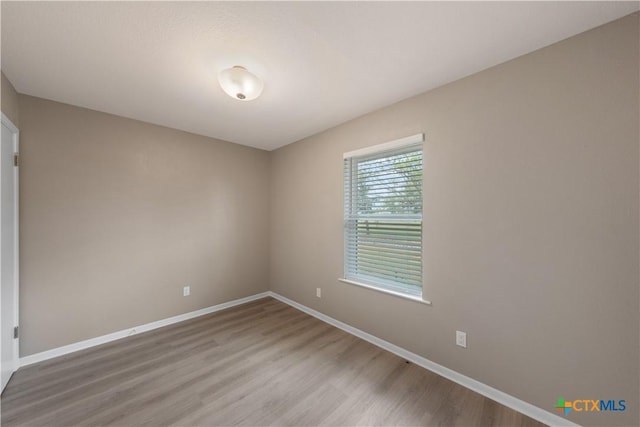 unfurnished room with hardwood / wood-style floors