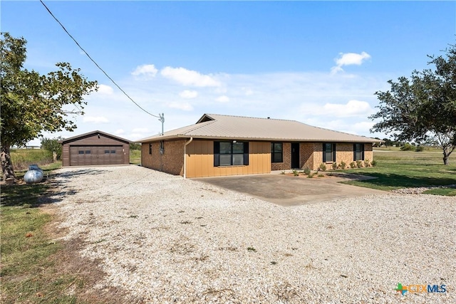 ranch-style house featuring a garage, an outdoor structure, and a front yard