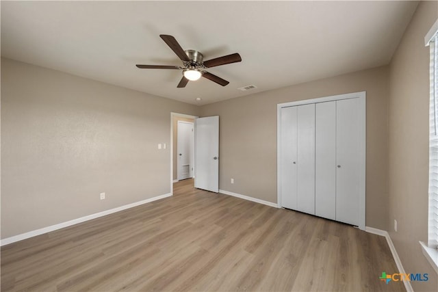 unfurnished bedroom with ceiling fan, a closet, and light wood-type flooring