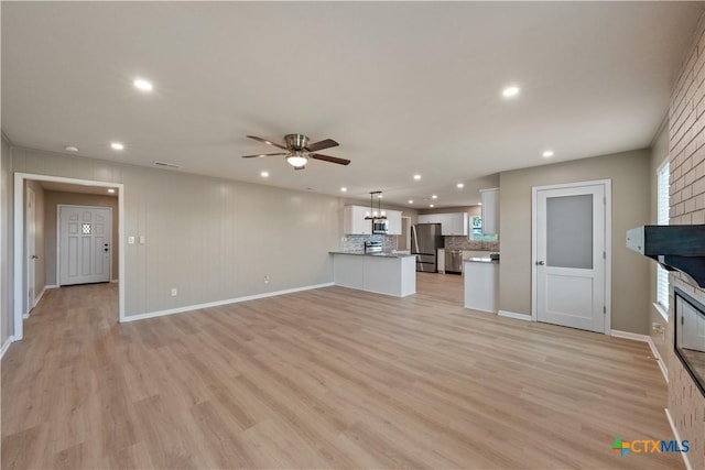 unfurnished living room with ceiling fan and light wood-type flooring