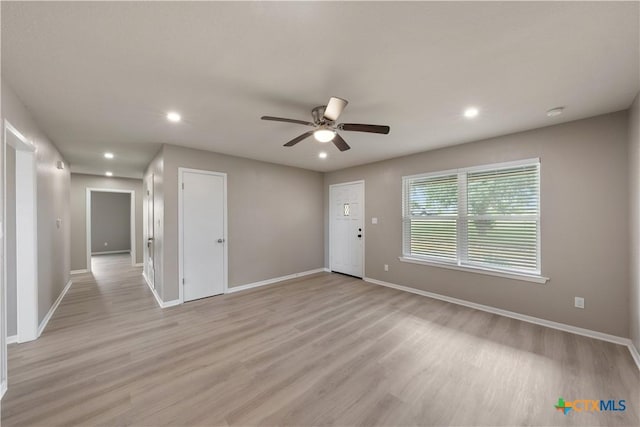 spare room featuring ceiling fan and light hardwood / wood-style flooring