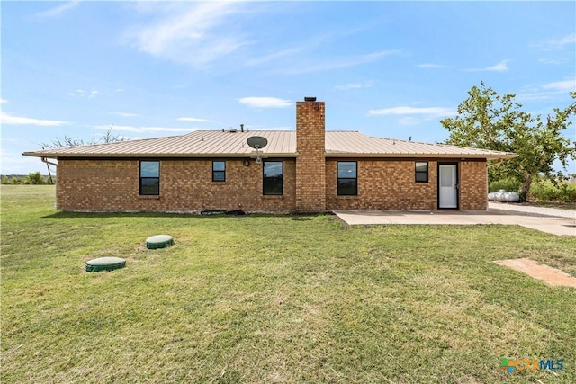 rear view of house featuring a yard and a patio