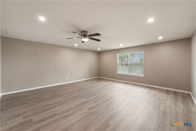 empty room with ceiling fan and light wood-type flooring