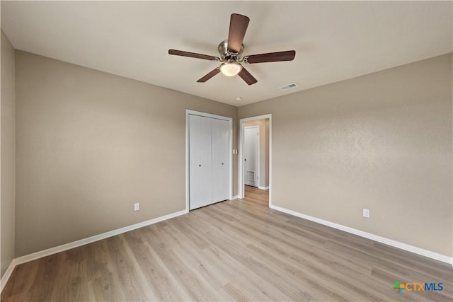 unfurnished bedroom featuring a closet, ceiling fan, and light hardwood / wood-style flooring