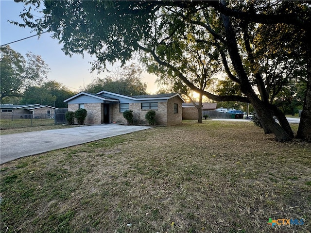 ranch-style home with a lawn