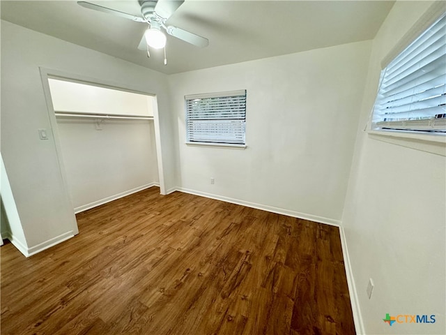 unfurnished bedroom with ceiling fan, a closet, and wood-type flooring