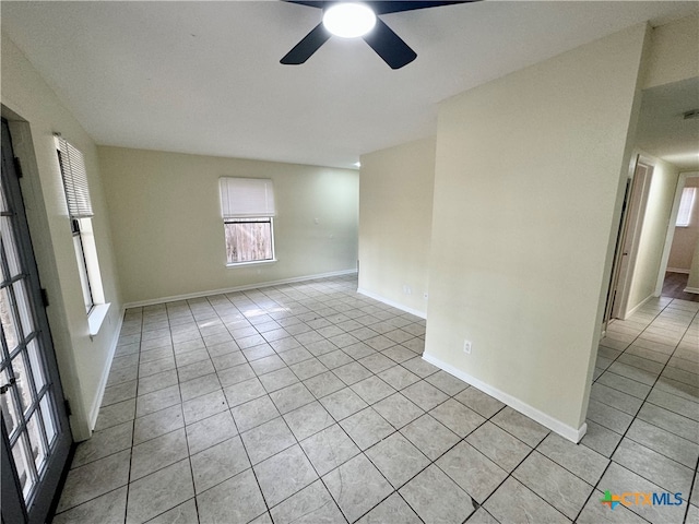 tiled spare room with ceiling fan