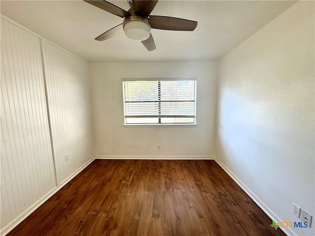 spare room featuring dark hardwood / wood-style flooring and ceiling fan