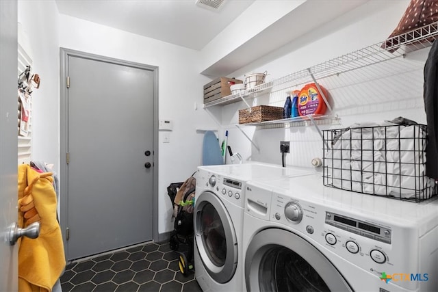 laundry room featuring dark tile patterned flooring and separate washer and dryer