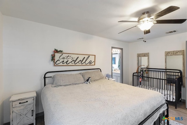 bedroom with hardwood / wood-style floors, ceiling fan, and connected bathroom