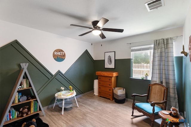 sitting room with ceiling fan and light wood-type flooring