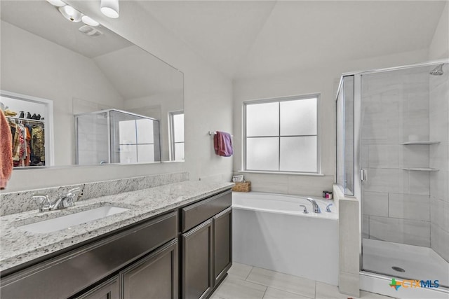 bathroom with tile patterned flooring, vanity, independent shower and bath, and lofted ceiling