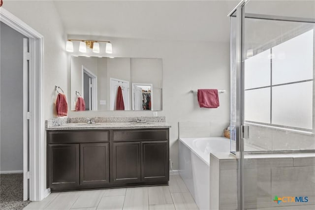 bathroom featuring vanity and independent shower and bath