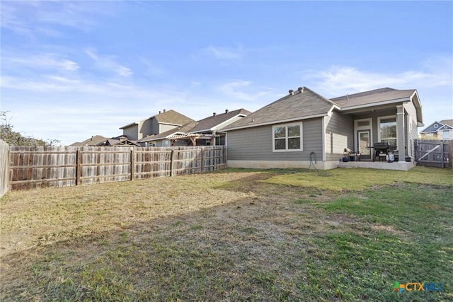 rear view of property featuring a lawn and a patio area