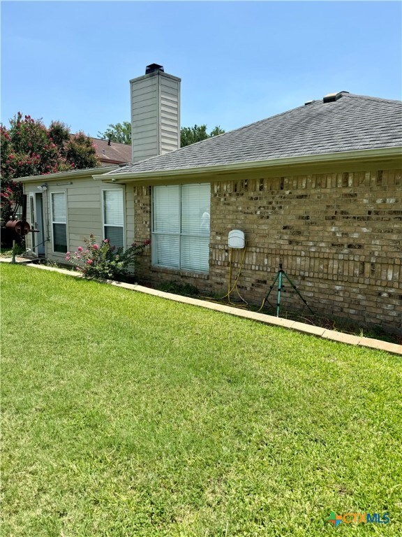 rear view of property with a yard