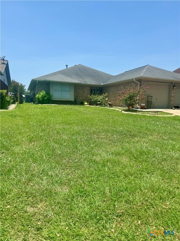 ranch-style house featuring a garage and a front lawn