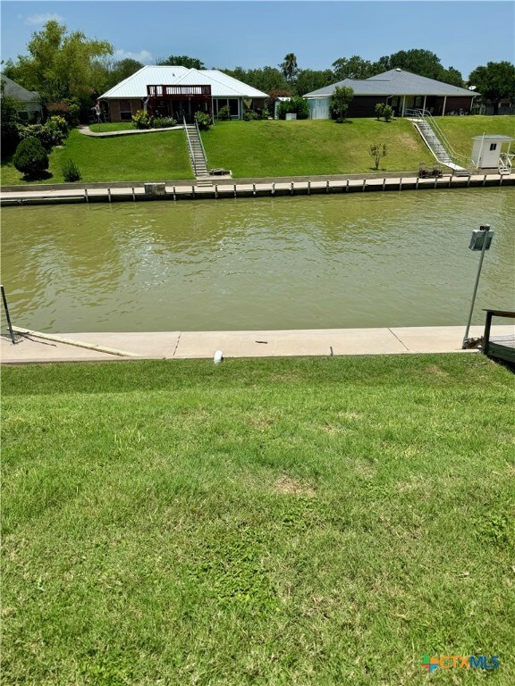 dock area with a water view and a yard