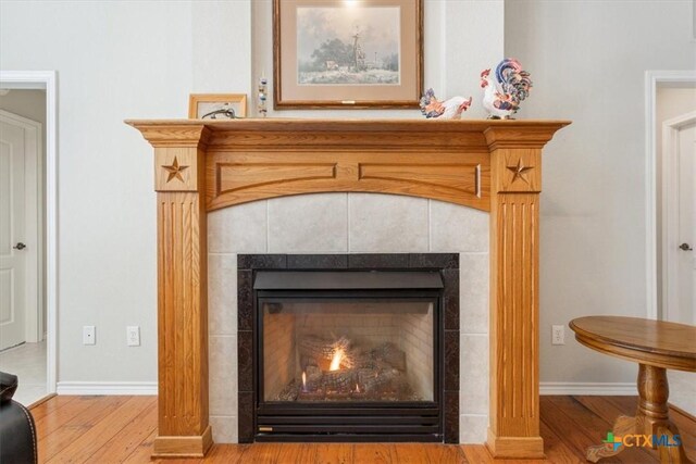 room details featuring hardwood / wood-style floors and a tile fireplace