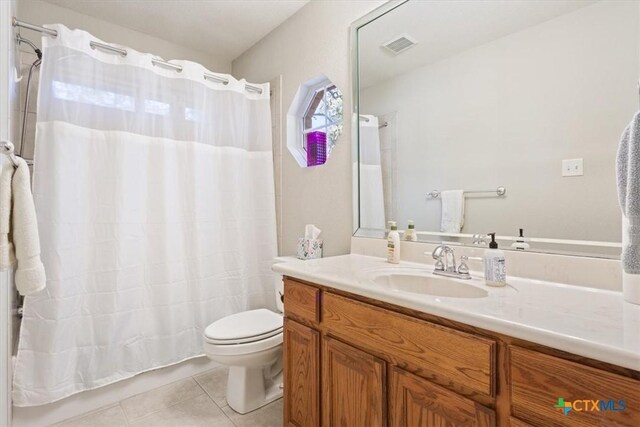 bathroom with tile patterned flooring, vanity, and toilet