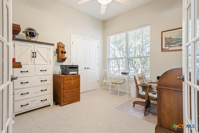 carpeted home office featuring french doors and ceiling fan