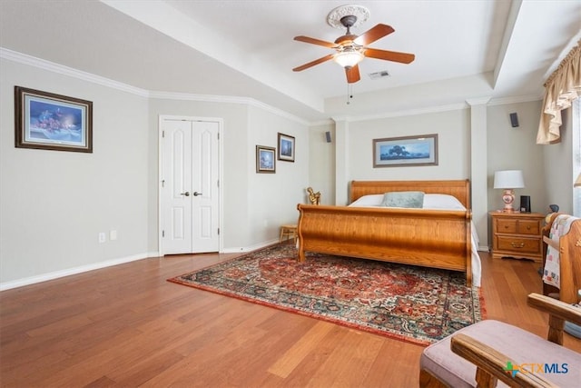 bedroom with hardwood / wood-style floors, ceiling fan, and crown molding