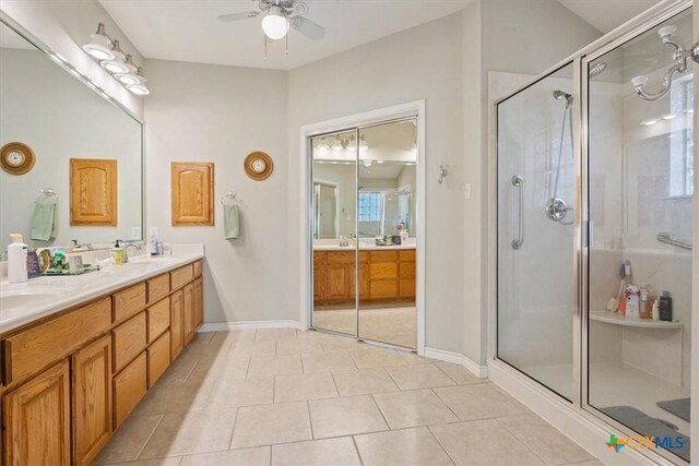 bathroom with tile patterned flooring, vanity, walk in shower, and ceiling fan