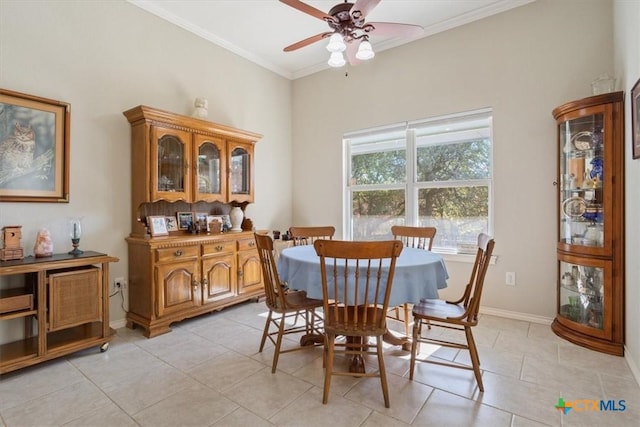 tiled dining room with ceiling fan and ornamental molding