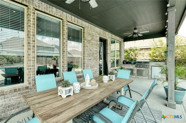 view of patio / terrace featuring exterior kitchen, a ceiling fan, outdoor dining space, and a grill