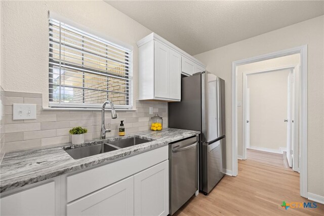 116 Spur Dr, Copperas Cove, TX 76522 - kitchen with stainless steel dishwasher, tasteful backsplash, white cabinetry, and light wood-style flooring