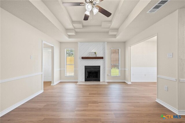 116 Spur Dr, Copperas Cove, TX 76522 - unfurnished living room featuring a raised ceiling, light wood-style floors, a ceiling fan, and a fireplace