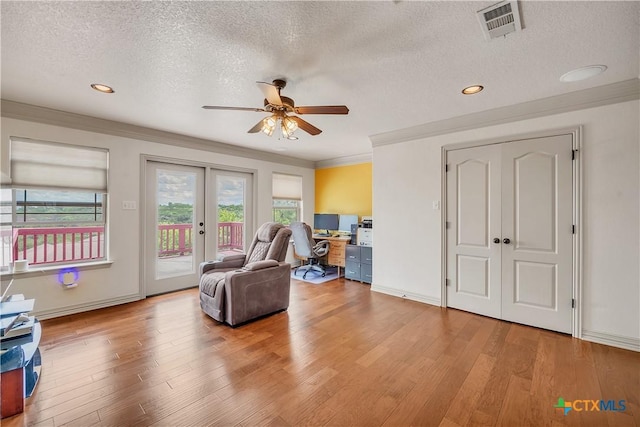 sitting room with french doors, a ceiling fan, light wood-style floors, a textured ceiling, and a desk